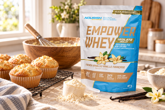 NWP French Vanilla Empower Whey Isolate beside freshly baked muffins and a mixing bowl.